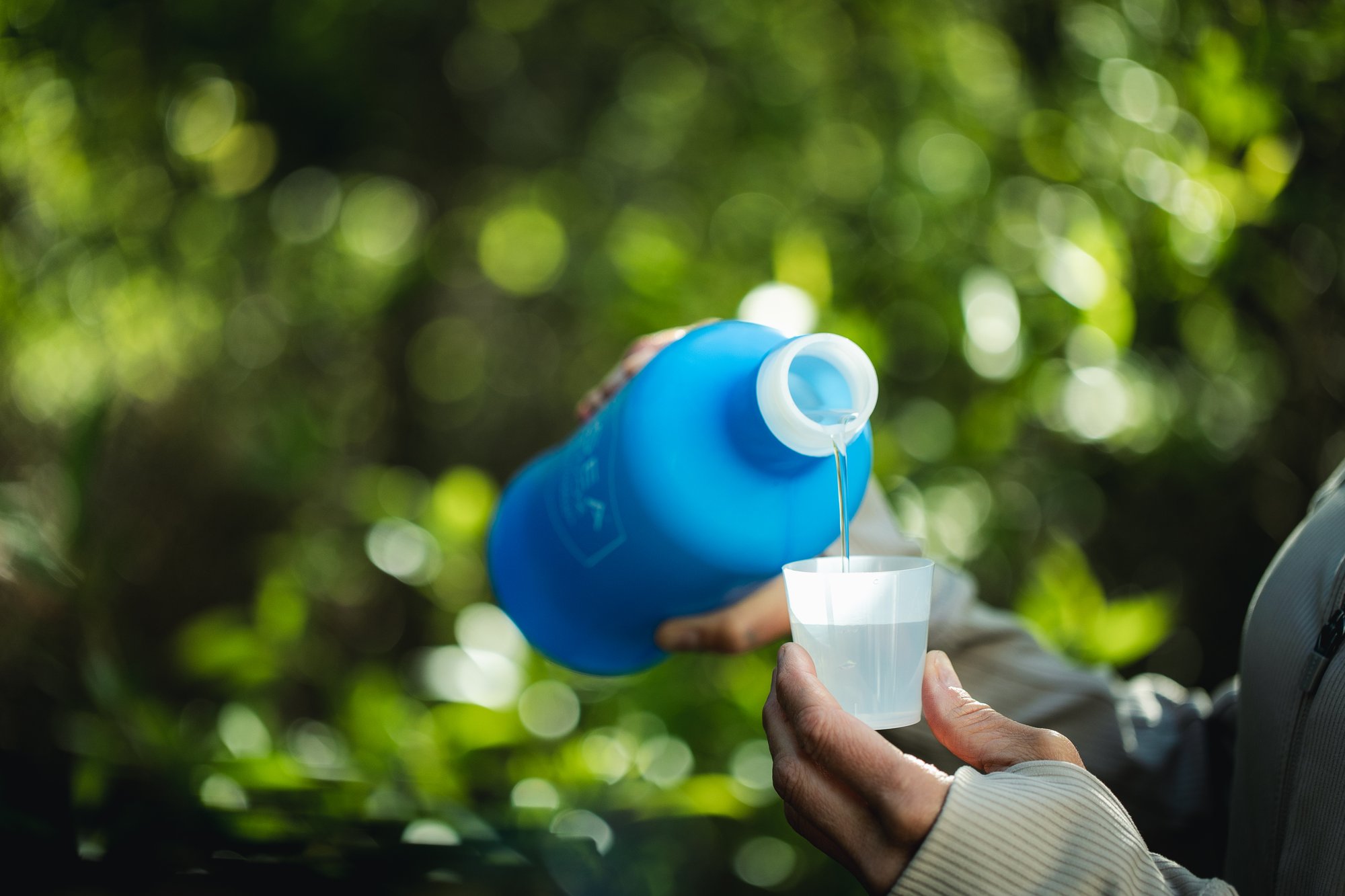 Universal_ARS_Woman Pouring Bottle in Woods 3 (1)