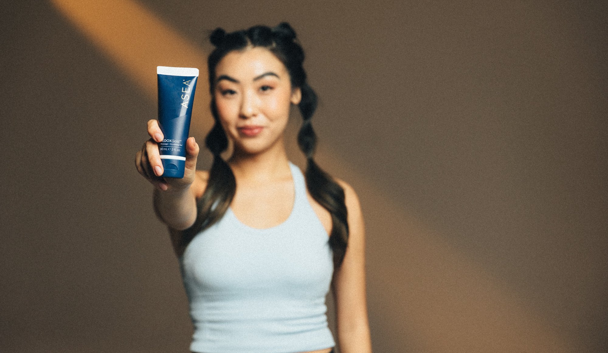 REDOXGold Woman holding tube out in front-1-1